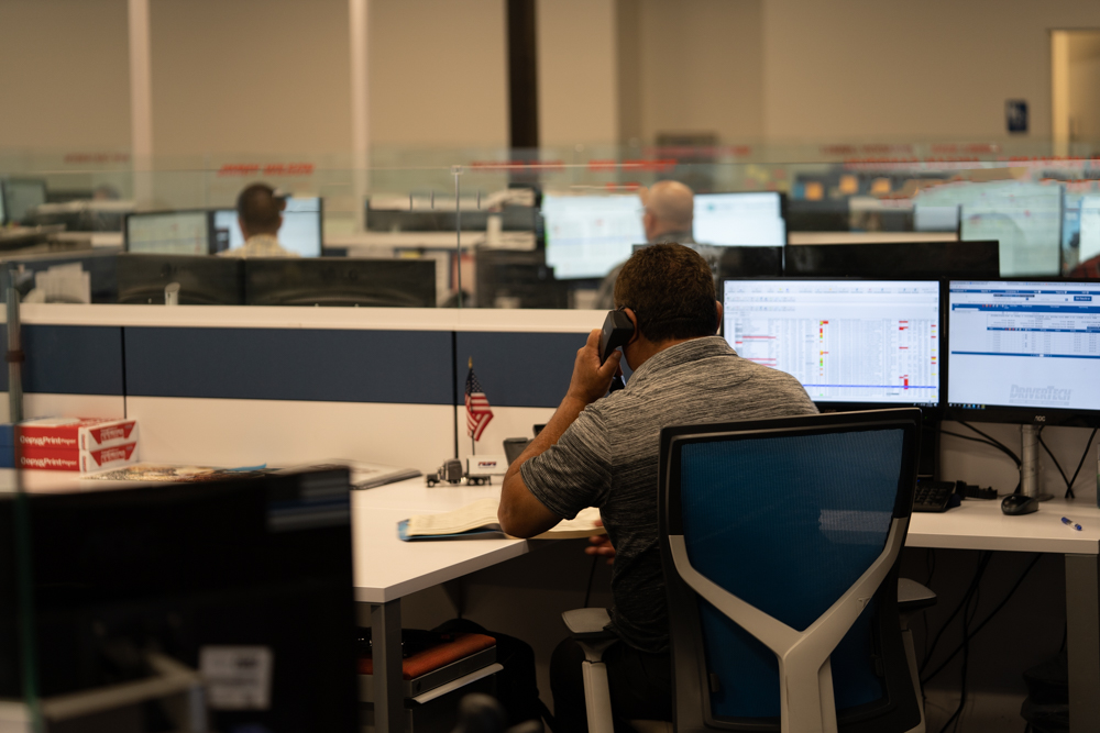 pride transport dispatcher employee on the phone at his desk