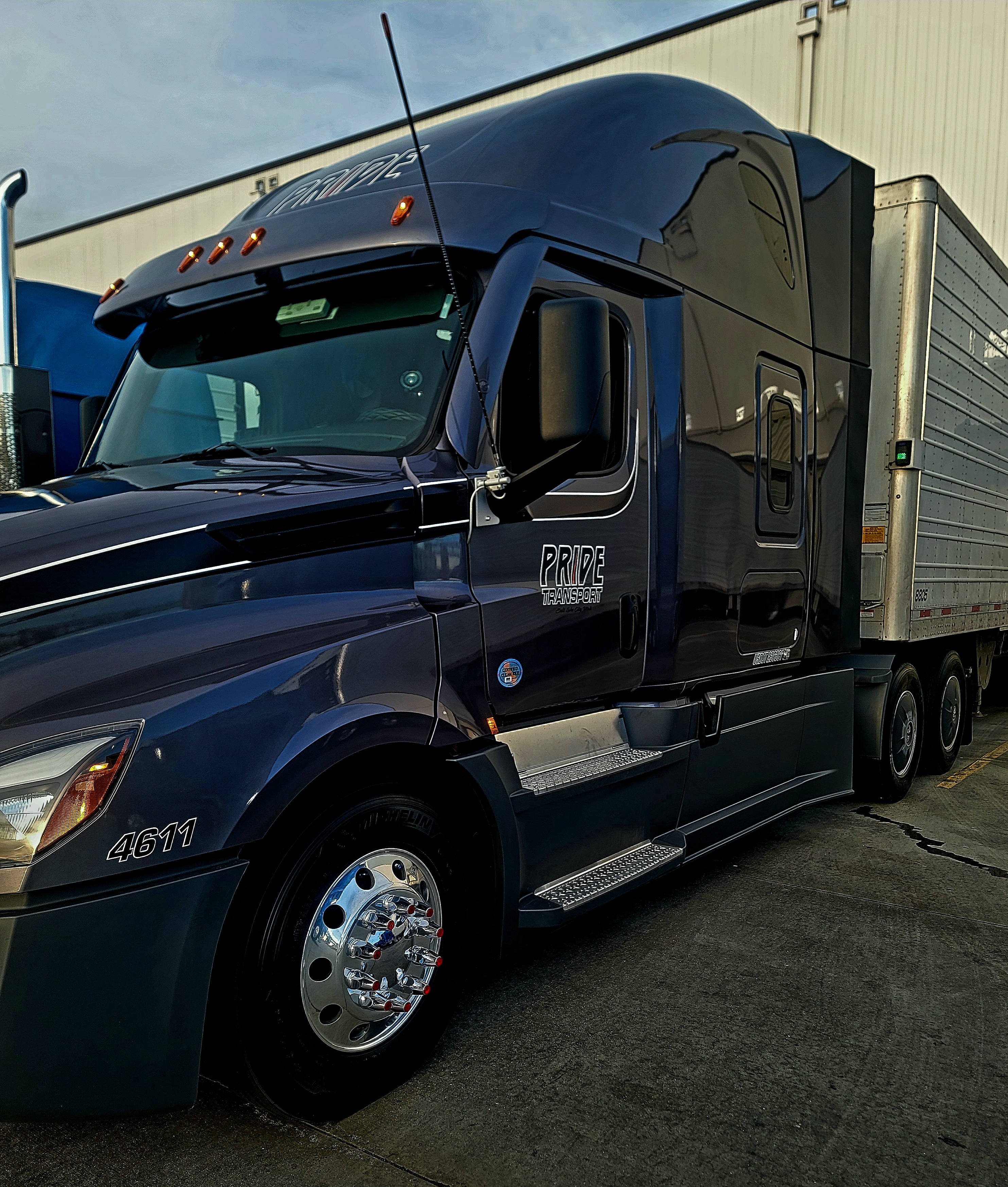 pride transport blue truck at loading dock