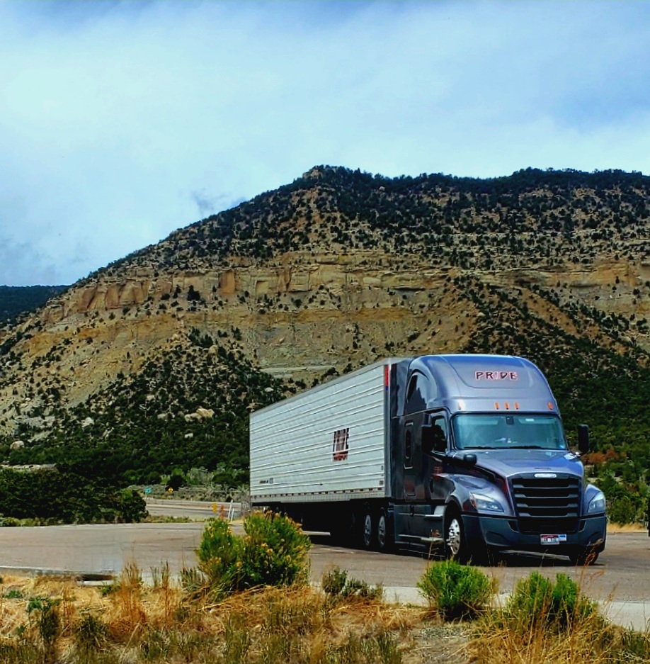 pride transport truck parked with mountain background