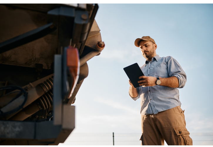 man holding tablet inspecting an 18 wheeler truck