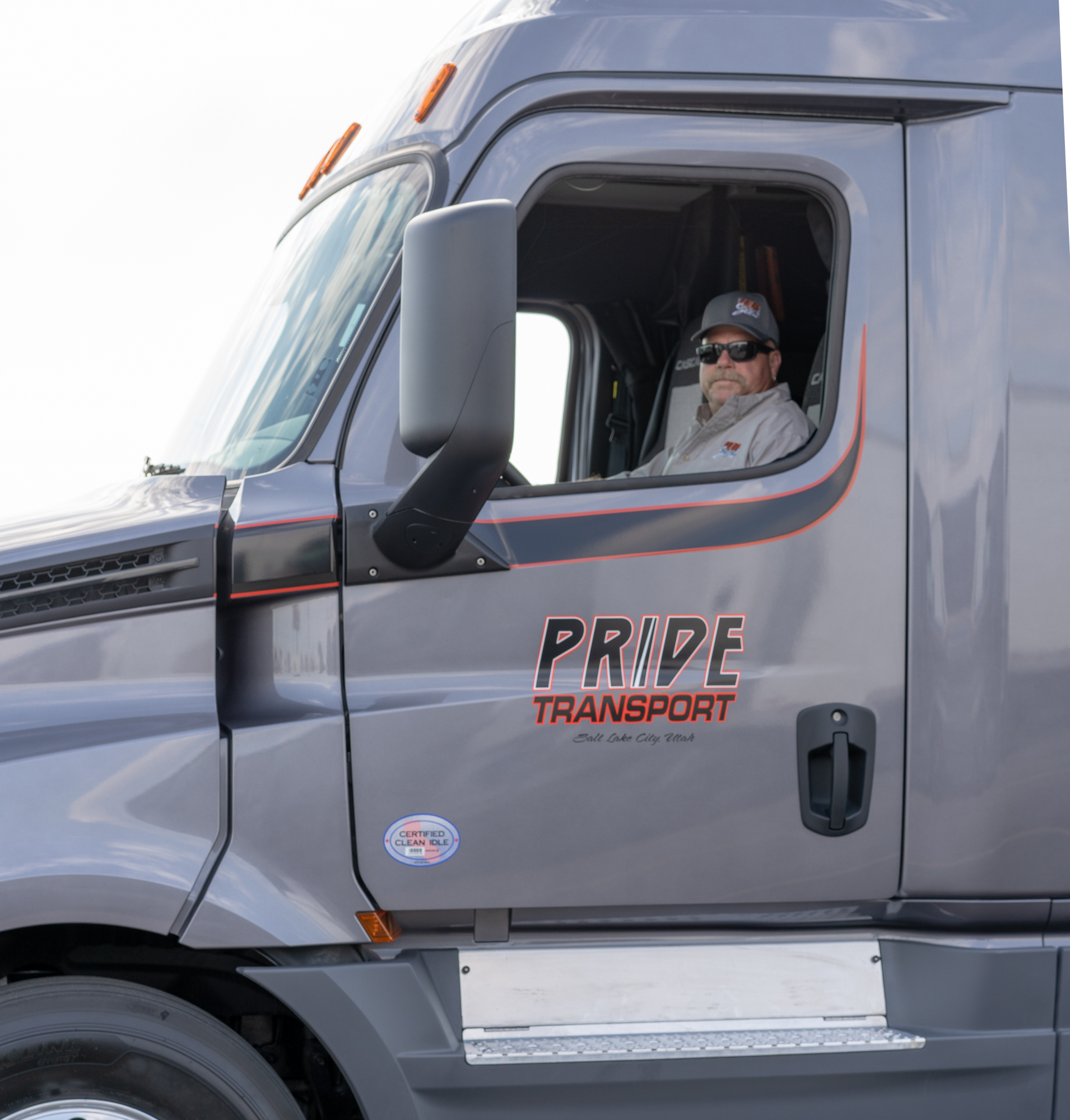 pride transport truck driver smiling in drivers seat