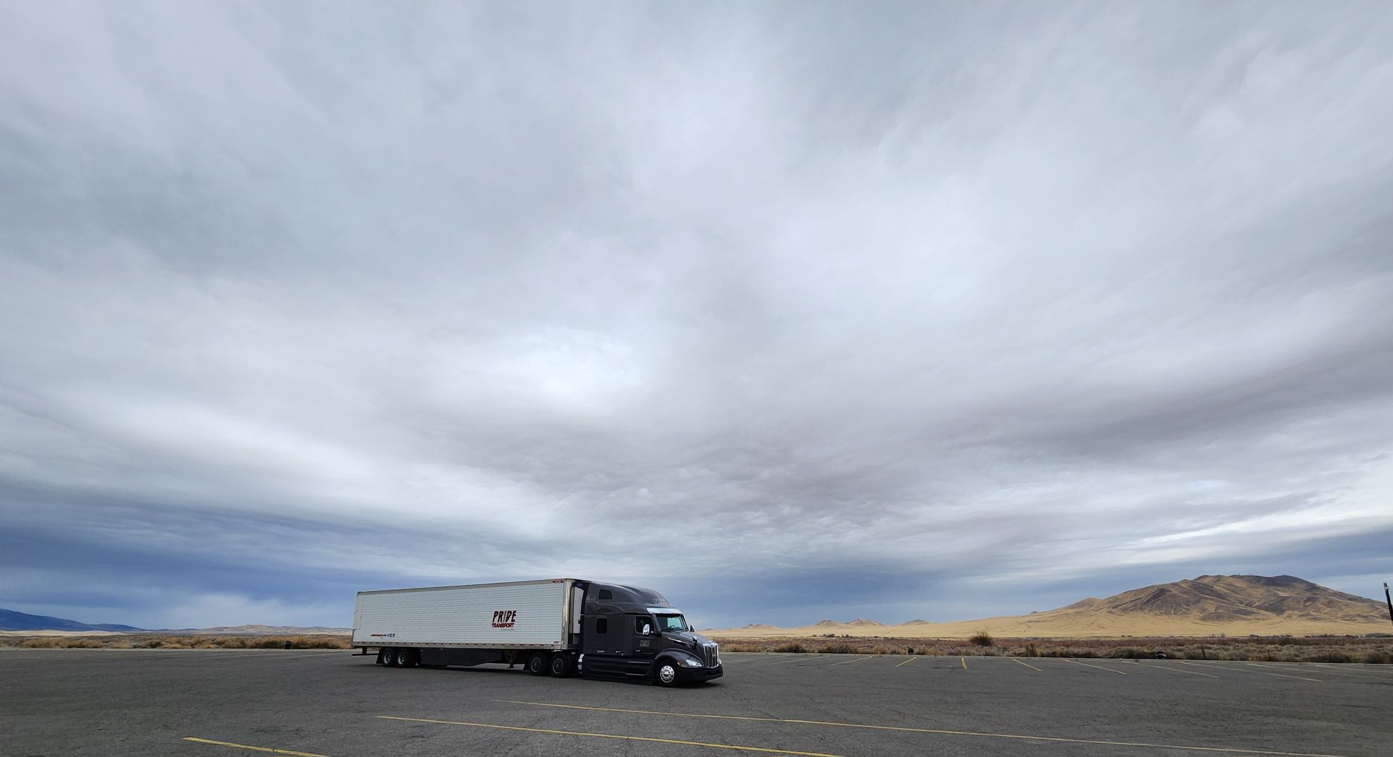 pride transport truck in parking lot and dramatic grey sky in background