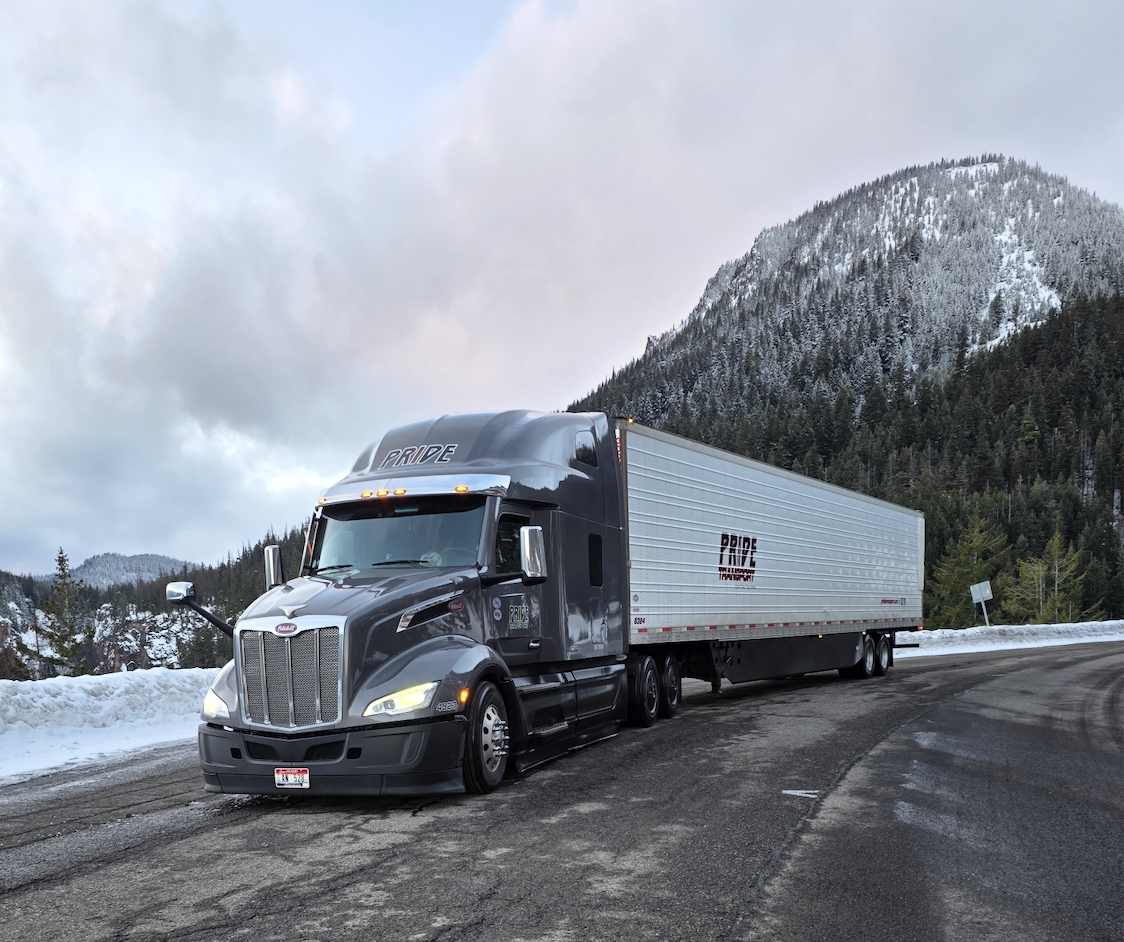 pride transport truck parked near water