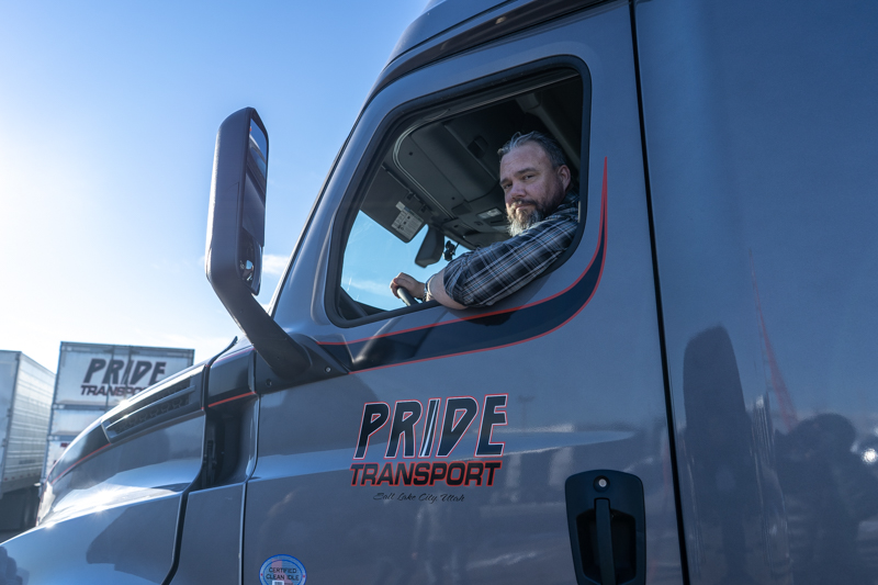 pride transport driver in truck smiling