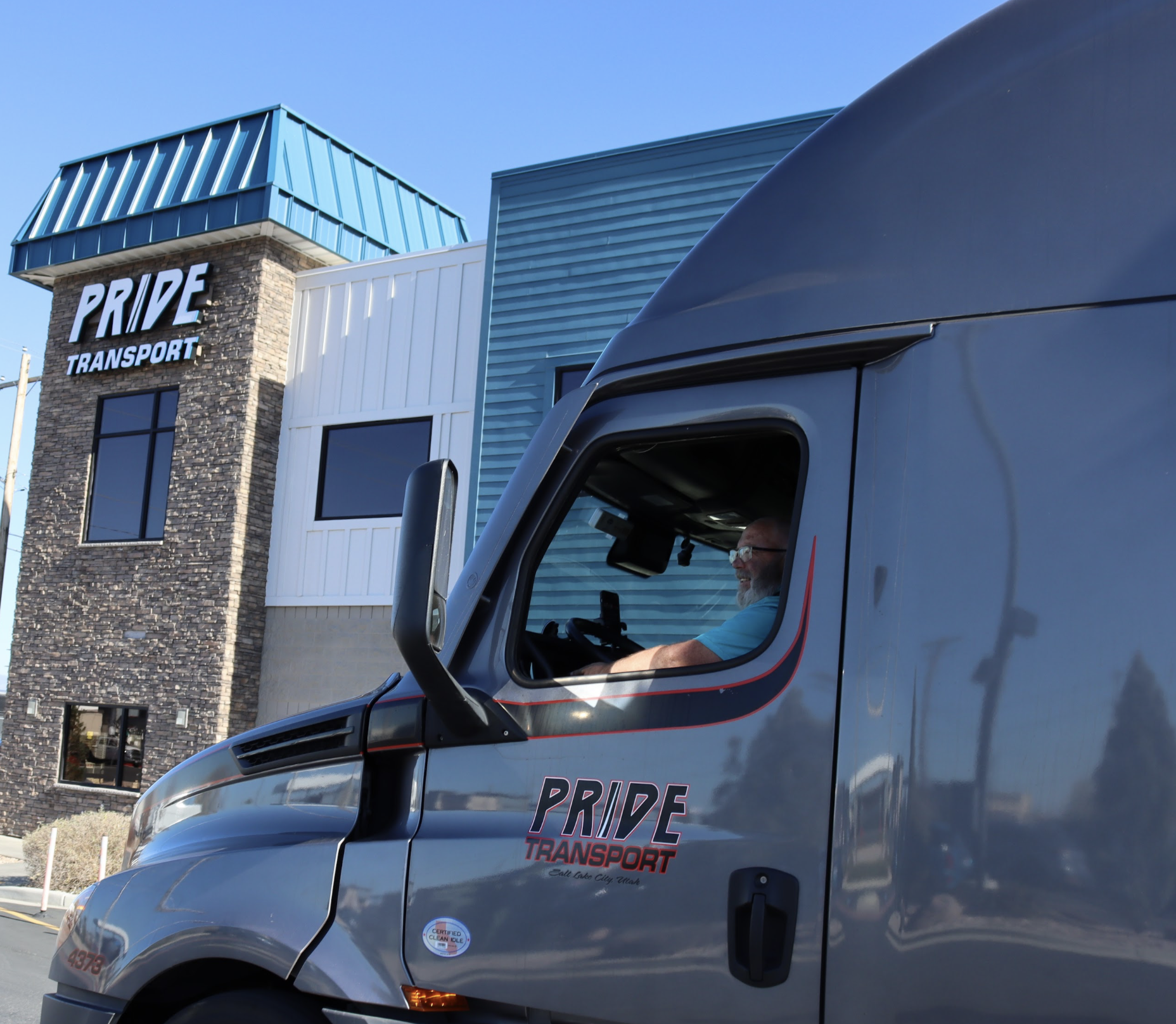 driving truck in front of pride transport building