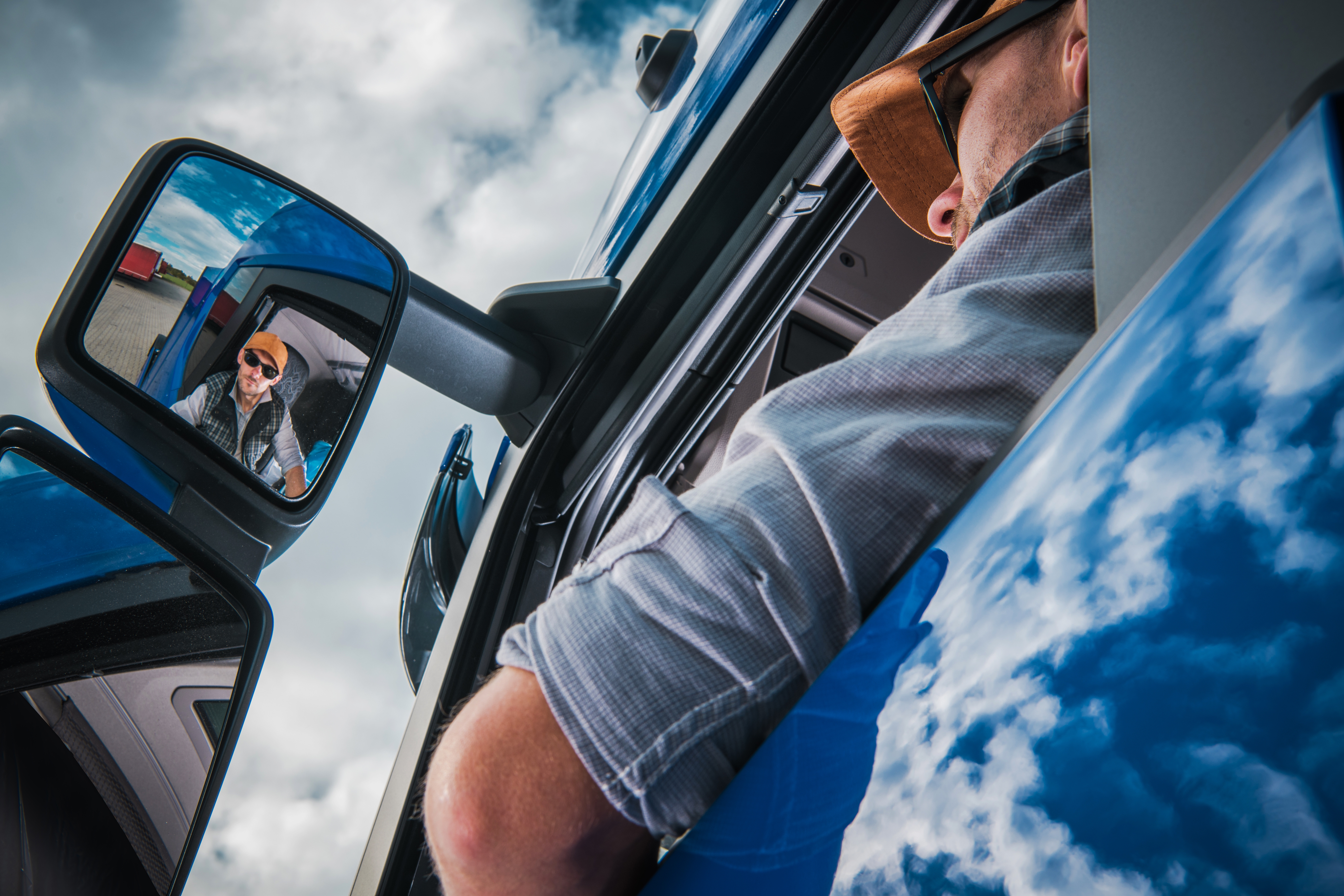 truck driver looking out of their driver side mirror