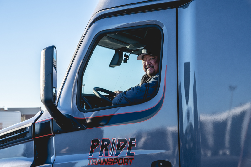 pride transport driver smiling out of truck