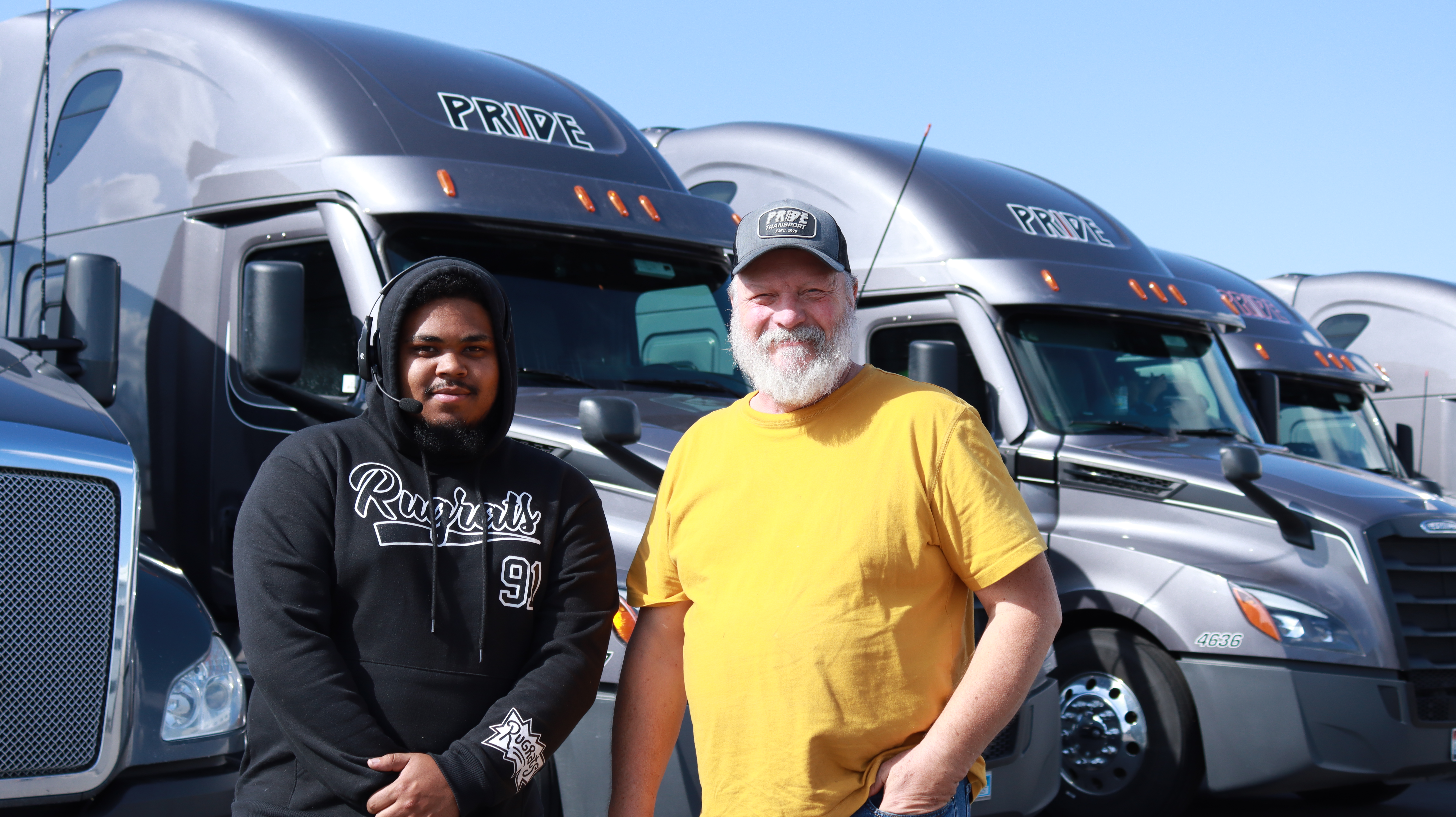 two pride transports employees standing in front of pride trucks