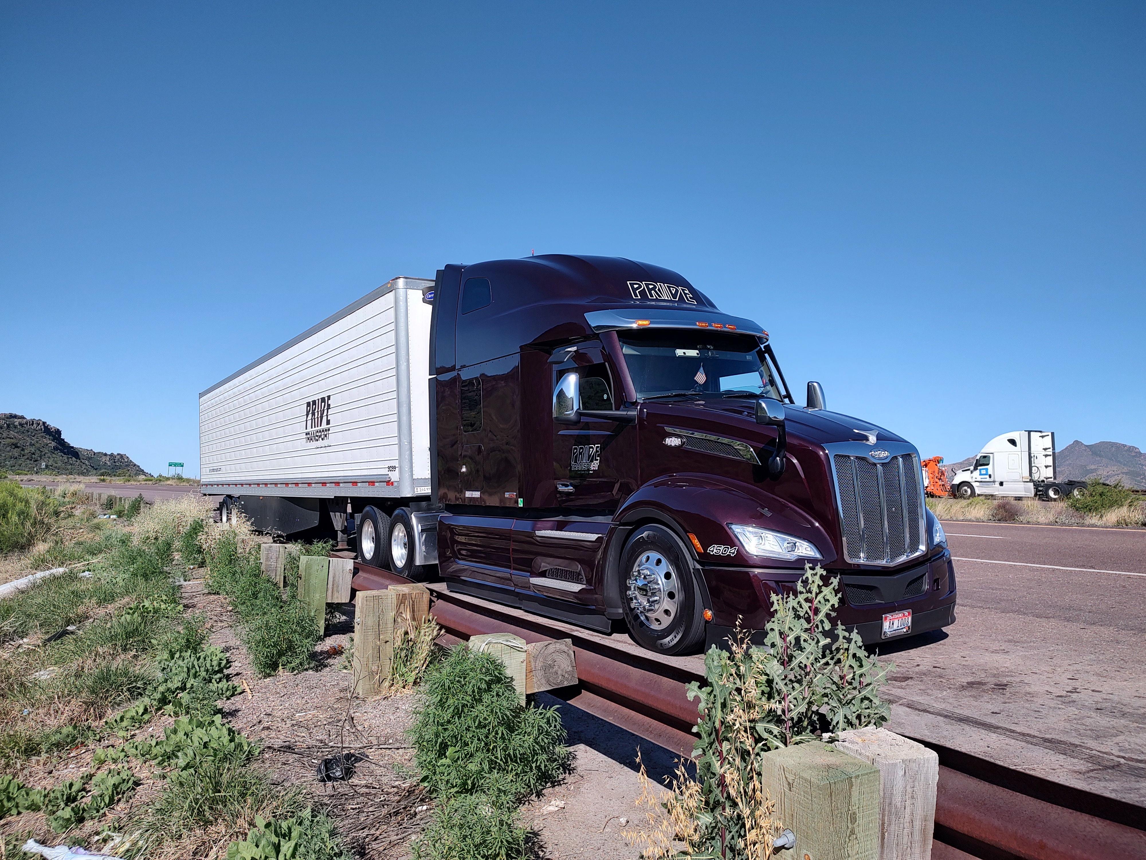 maroon pride transport truck parked on shoulder of road