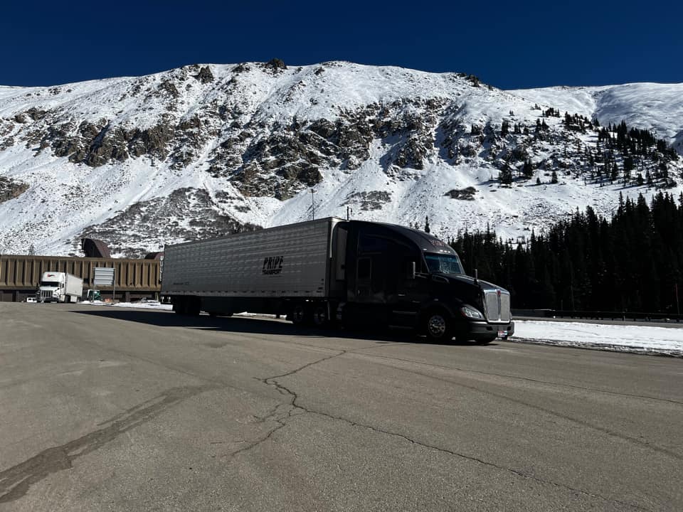 pride transport truck with snow and mountains in background