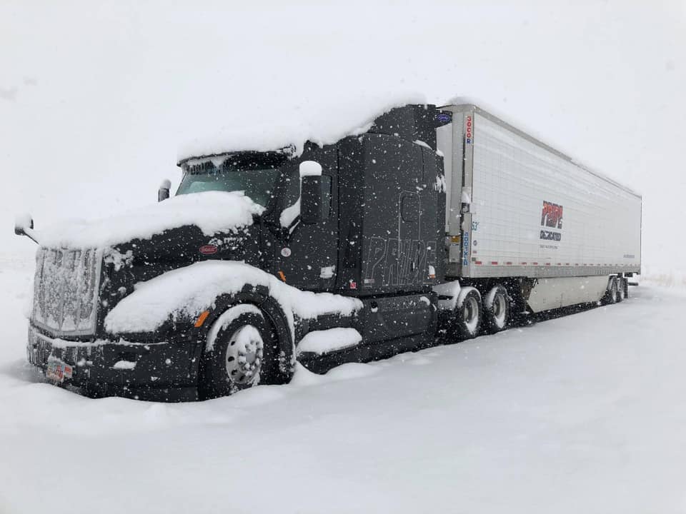 pride transport truck parked in snow